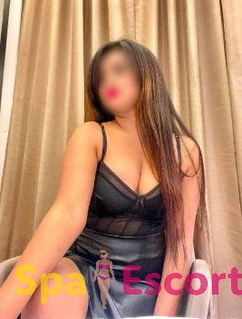 Navi Mumbai escort preparing wine in a cozy hotel suite.